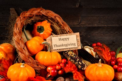 Harvest cornucopia close up with Happy Thanksgiving gift tag on dark wood background