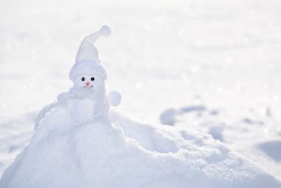 Little white snowman near snowbank
