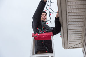 Man Hanging Christmas Lights Holiday Ladder Safety