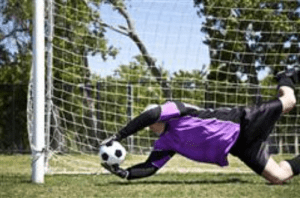 soccer goalie dives for goal