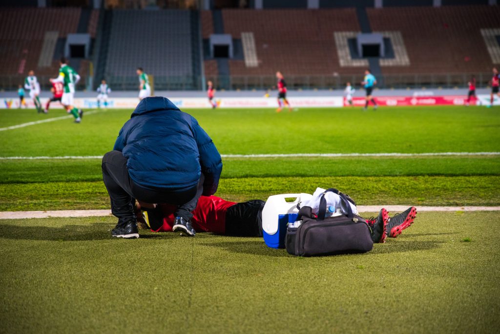 Urgent injury - a sports doctor cares for the football player